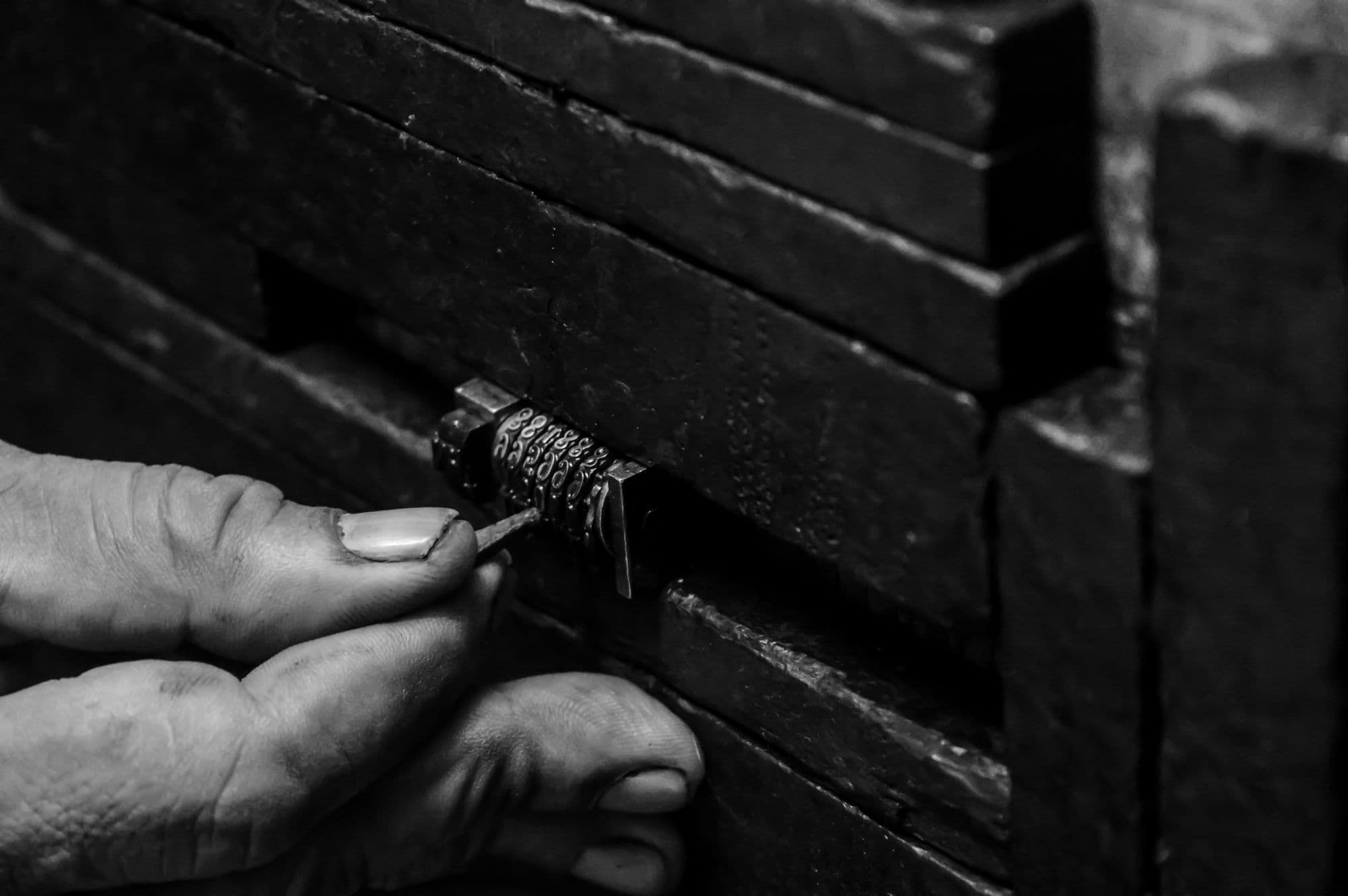 Locksmith picking a lock on a black door